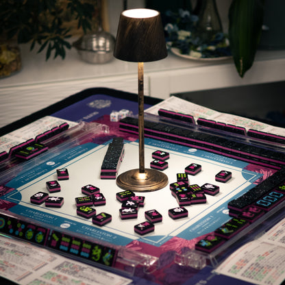 Neon Daze American Mahjong tiles from Mahj Queen™ on the Queen's Garden mat.  This set features modernized designs for easier identification—with bold black faces with neon ink and a glittery back.